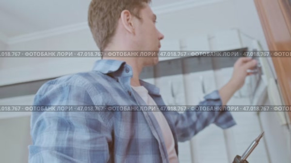 An electrician installs and inspects circuit breakers, ensuring a stable and safe electrical system in the house. Стоковое видео, видеограф Svetlana Golovco / Фотобанк Лори