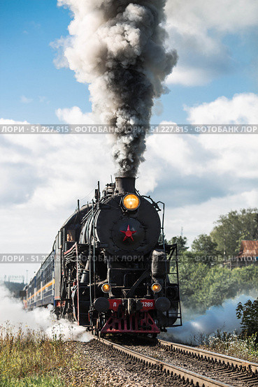 An old Soviet steam locomotive of the L series. The Ruskeala Express retro train is on its way to the mountain park. Thick smoke is coming from the chimney. Russia, Republic of Karelia, Sortavala, August 10, 2025. Редакционное фото, фотограф Photojuli / Фотобанк Лори