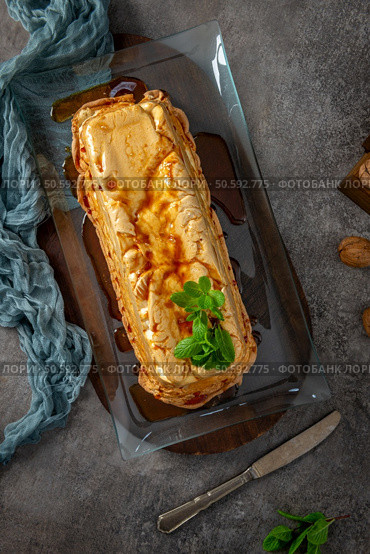 An overhead shot features a whole molotof, a traditional caramelized egg white pudding, generously drizzled with sweet syrup and garnished with fresh mint sprigs on a glass platter. Стоковое фото, агентство Ingram Publishing / Фотобанк Лори