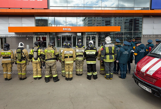 ANGARSK, IRKUTSK REGION, RUSSIA - April 08, 2025: Fire brigade team in special clothing and helmets lining up before conducting a preventive firefighting training session in a city shopping mall. Редакционное фото, фотограф Виктория Катьянова / Фотобанк Лори