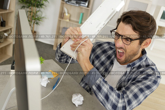 angry and upset man wants to break his pc. Стоковое фото, агентство Ingram Publishing / Фотобанк Лори