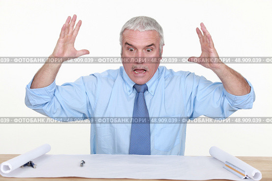 angry businessman looking at a blueprint. Стоковое фото, агентство Ingram Publishing / Фотобанк Лори