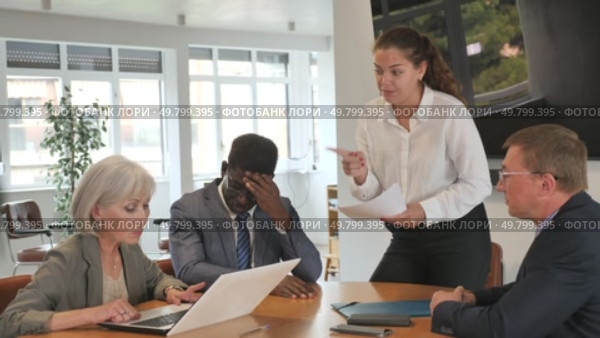 Angry young woman shouting at her business partners sitting around table in conference room. Стоковое видео, видеограф Яков Филимонов / Фотобанк Лори