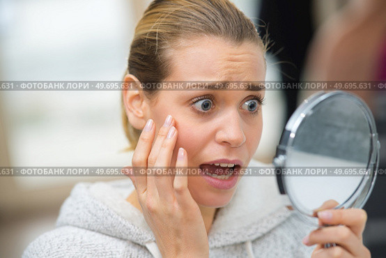 anguished young lady noticing wrinkles in the mirror. Стоковое фото, агентство Ingram Publishing / Фотобанк Лори