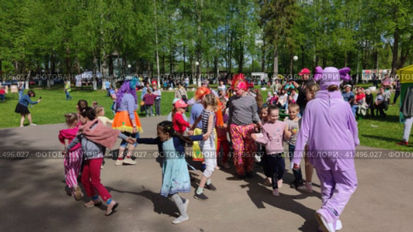 Аниматор играет с детьми на праздничном мероприятии в День защиты детей. An animator plays with children at a festive event on Children's Day. Редакционное видео, видеограф Мария / Фотобанк Лори