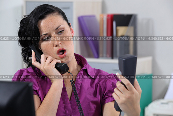 Annoyed receptionist answering ringing phones. Стоковое фото, фотограф Phovoir Images / Фотобанк Лори