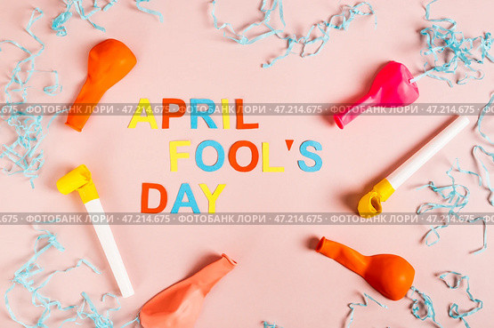 April Fools' Day made of colored letters, whistles, balloons and paper on pink top view. Стоковое фото, фотограф Елена Руй / Фотобанк Лори