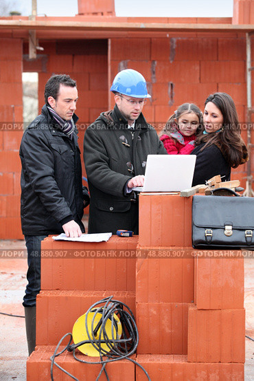 Architect and young family visiting house plot. Стоковое фото, агентство Ingram Publishing / Фотобанк Лори