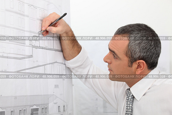Architect working on a blueprint. Стоковое фото, агентство Ingram Publishing / Фотобанк Лори