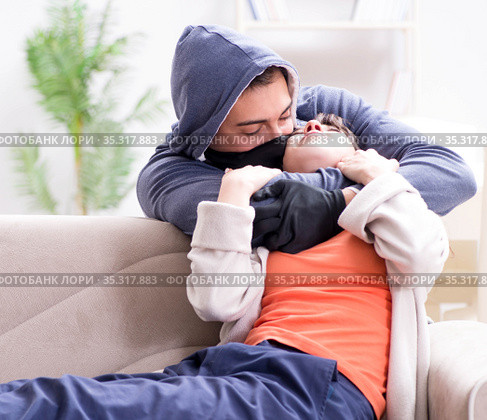 Armed man assaulting young woman at home. Стоковое фото, фотограф Elnur / Фотобанк Лори