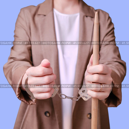 Arrested woman teacher handcuffed on a blue background, copy space. Стоковое фото, фотограф Андрей Журавлев / Фотобанк Лори
