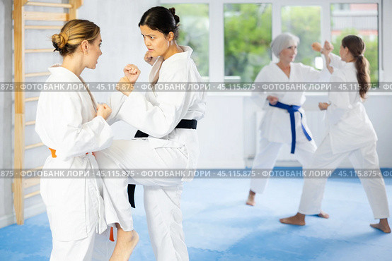 Asian female karateka honing kicking techniques during kumite. Стоковое фото, фотограф Яков Филимонов / Фотобанк Лори