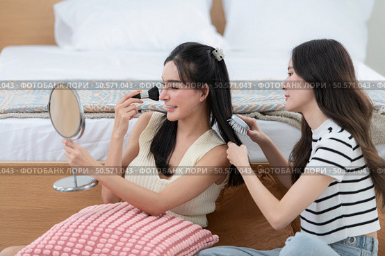 Asian young women conducting their weekly holiday routines from getting up, putting on cosmetics and relaxing. Стоковое фото, агентство Ingram Publishing / Фотобанк Лори