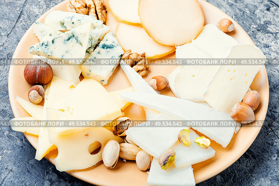 Assortment of different cheese types on plate.Piece of cheese. Cheese platter on plate. Стоковое фото, агентство Ingram Publishing / Фотобанк Лори