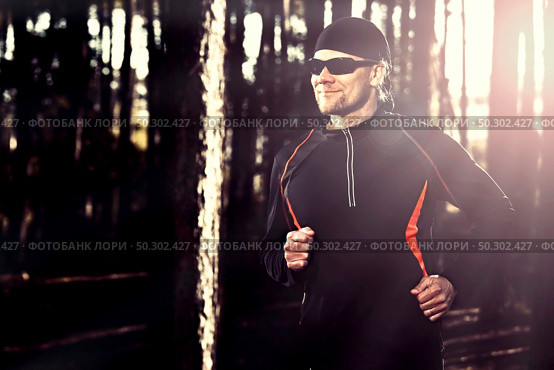 Athletic man doing exercise, running in the forest. Стоковое фото, агентство Ingram Publishing / Фотобанк Лори