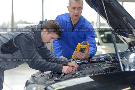 auto mechanic teacher and trainee performing tests at mechanic school. Стоковое фото, агентство Ingram Publishing / Фотобанк Лори