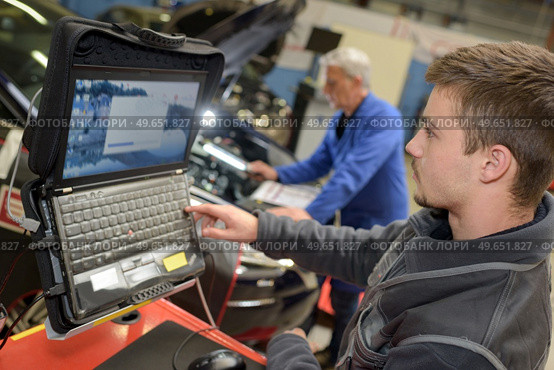 auto mechanic teacher and trainee performing tests at mechanic school. Стоковое фото, агентство Ingram Publishing / Фотобанк Лори