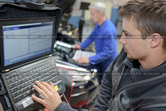 auto mechanic teacher and trainee performing tests at mechanic school. Стоковое фото, агентство Ingram Publishing / Фотобанк Лори