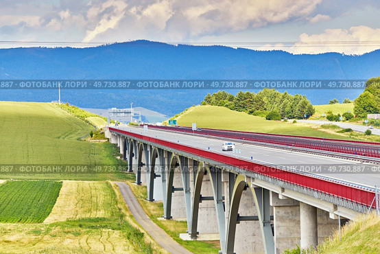 Autostrada highway in Europe. D1 magistal near Spissky hrad, arched bridge. Motorway viaduct bridge, Spis region, Slovakia. Green summer fields, hills of Tatra mountains. Travel in vacations. Стоковое фото, агентство Ingram Publishing / Фотобанк Лори