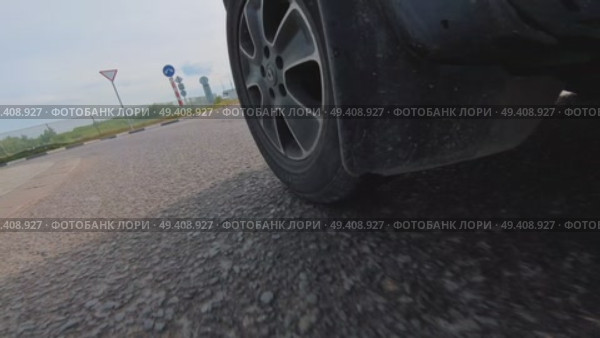 Автомобиль едет по мокрой дороге с частично видимой шиной. Стоковое видео, видеограф Ярославский Максим / Фотобанк Лори