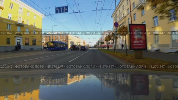 Автомобиль катится по пустынном проспекту Ленина города Петрозаводска в историческом центре солнечным осенним утром. Вид с капота автомобиля. Оригинальный звук города. Редакционное видео, видеограф Sergei Gorin / Фотобанк Лори
