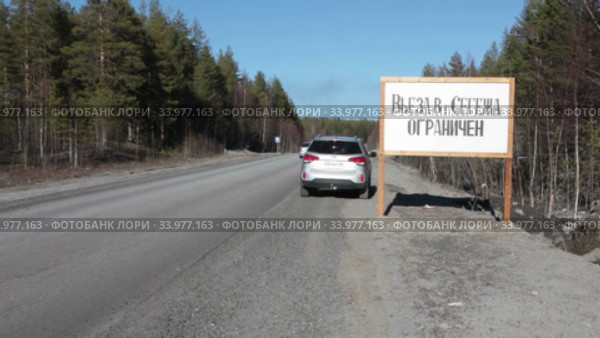 Автомобиль с номерами региона Санкт-Петербург стоит на обочине, возле стенда с надписью: Въезд в г. Сегежа ограничен. Республика Карелия (2020 год). Редакционное видео, видеограф Кекяляйнен Андрей / Фотобанк Лори