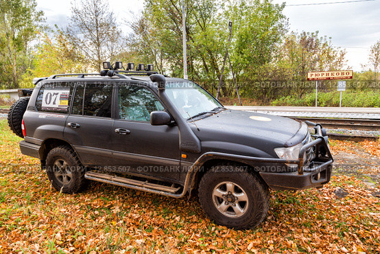 Автомобиль Toyota Land Cruiser 100 на фоне железнодорожной станции Рюриково (2015 год). Редакционное фото, фотограф Сергей Лаврентьев / Фотобанк Лори