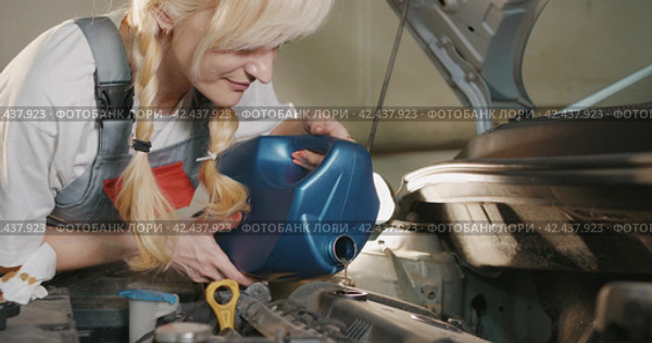 Автосервис. Attractive female mechanic carries out engine repairs in garage workshop. Стоковое видео, видеограф EStarodubov / Фотобанк Лори