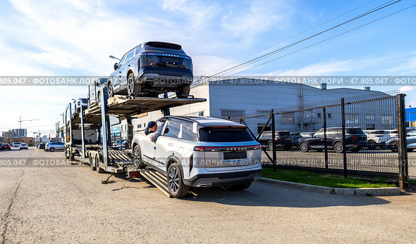 Автовоз привез новые автомобили официальному дилеру. Грузовик-автовоз с автомобилями Jaecoo. Редакционное фото, фотограф FotograFF / Фотобанк Лори