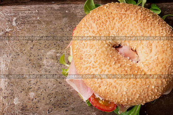 Bagels with Italian ham prosciutto, cream cheese, tomatoes and salad  on rustic metal tray with flowers. Top View. Стоковое фото, агентство Ingram Publishing / Фотобанк Лори