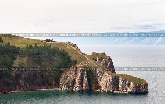 Baikal Lake in August day. View of rocky cape Three Brothers or Saga-Khushun cliff - popular place for tourists and natural landmark of Olkhon Island. Scenic landscape. Summer holidays and travels. Стоковое фото, фотограф Виктория Катьянова / Фотобанк Лори