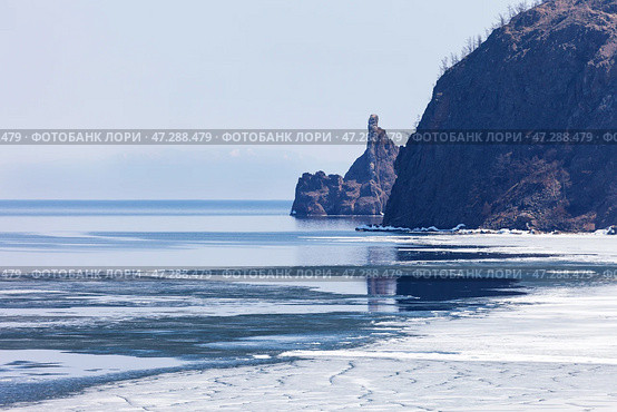 Baikal Lake in May. View from rocky shore of Olkhon Island to ice drift and to famous Cape Khoboy - natural landmark of lake Baikal. Beautiful spring landscape. Natural background. Changing seasons. Стоковое фото, фотограф Виктория Катьянова / Фотобанк Лори