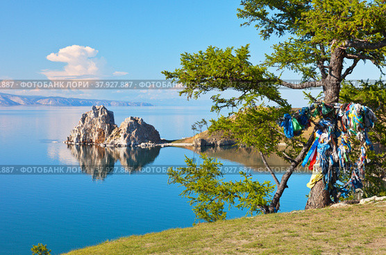 Baikal Lake in the summer. Olkhon Island is a popular holiday destination for travelers from different countries. They leave their colored ribbons on the trees, making wishes near the Shamanka Rock. Стоковое фото, фотограф Виктория Катьянова / Фотобанк Лори