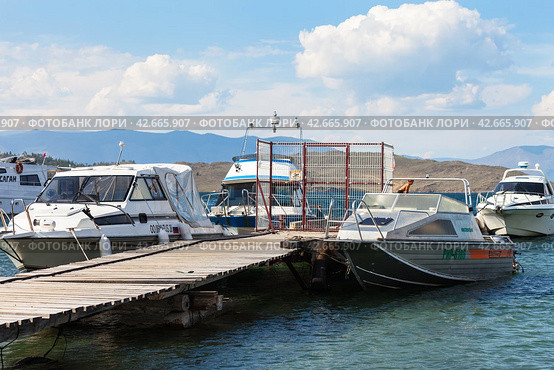 BAIKAL LAKE, OLKHON ISLAND, SAKHYURTA VILLAGE, IRKUTSK REGION, RUSSIA - August 14, 2023: View of the ship pier in the village of Sakhyurta on a sunny day. Summer cruises and travel. Редакционное фото, фотограф Виктория Катьянова / Фотобанк Лори