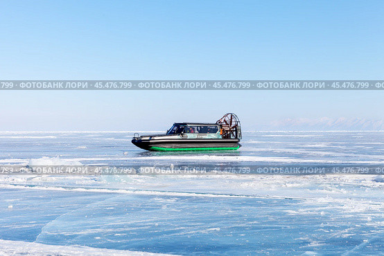 BAIKAL LAKE, OLKHON ISLAND, UZURY VILLAGE, IRKUTSK REGION, RUSSIA - February 23, 2023: Group of tourists travels across icy expanses of Baikal Lake on Sever airboat on sunny winter day. Редакционное фото, фотограф Виктория Катьянова / Фотобанк Лори