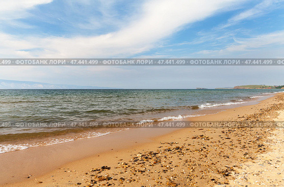 Baikal Lake on sunny summer day. Beautiful sandy beach of Saraiskiy Bay is a favorite vacation spot for tourists on Olkhon Island. Summer travels and recreation. Natural background. Scenic seascape. Стоковое фото, фотограф Виктория Катьянова / Фотобанк Лори