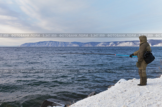Байкал в декабре. Рыбак на берегу ловит омуля на удочку. Стоковое фото, фотограф Виктория Катьянова / Фотобанк Лори