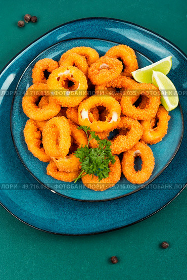 Baked breaded calamari or octopus rings. Flat lay.. Deep fried squid rings. Стоковое фото, агентство Ingram Publishing / Фотобанк Лори