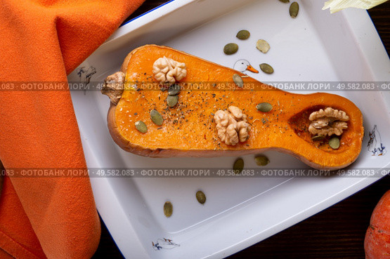 baked pumpkin with walnuts and seeds,   served at wooden brown table with  orange  napkin. flat lay. healthy life concept. Стоковое фото, агентство Ingram Publishing / Фотобанк Лори