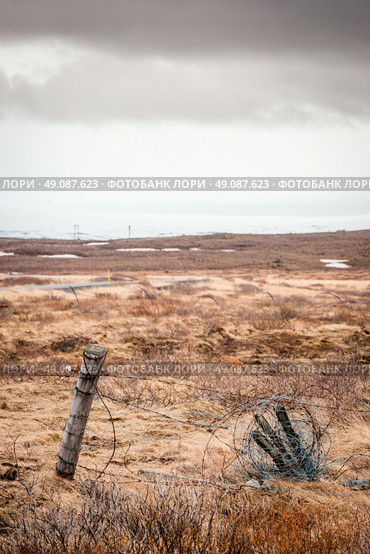 Barb wire on a fence in cloudy weather on a battlefield. Стоковое фото, агентство Ingram Publishing / Фотобанк Лори