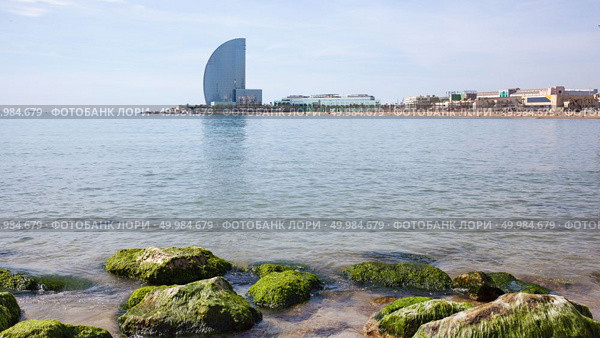Barceloneta Beach and Hotel Vela . Barcelona, Spain. Barceloneta Beach - one of the most popular in the city. Barceloneta Beach and Hotel Vela. Стоковое фото, агентство Ingram Publishing / Фотобанк Лори