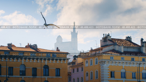 Basilique Notre-Dame de la Garde in the foggy background with red tiled roof Marseille houses (2018 год). Стоковое фото, фотограф Сергей Богомяко / Фотобанк Лори