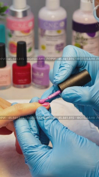 Beautician applying pink nail polish on fingernail. Стоковое AI-видео, аниматор Юрий Поздников / Фотобанк Лори