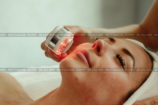 Beautician doing led light therapy to woman with problematic skin in SPA. Стоковое фото, фотограф Aleksandr Golubev / Фотобанк Лори