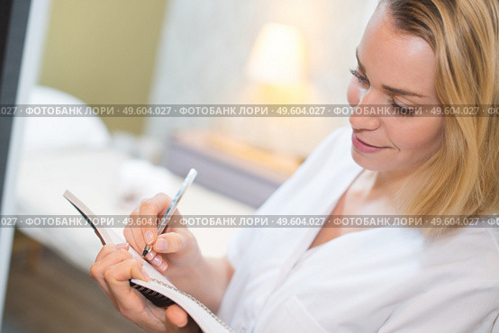 beautician making notes treatment room visible in background. Стоковое фото, агентство Ingram Publishing / Фотобанк Лори