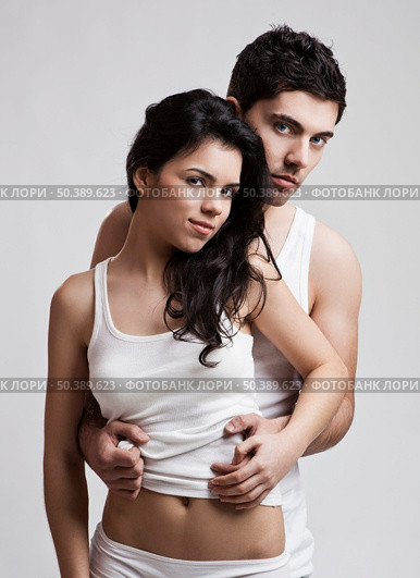 Beautiful and attractive young couple in underwear standing over a white background. Стоковое фото, агентство Ingram Publishing / Фотобанк Лори