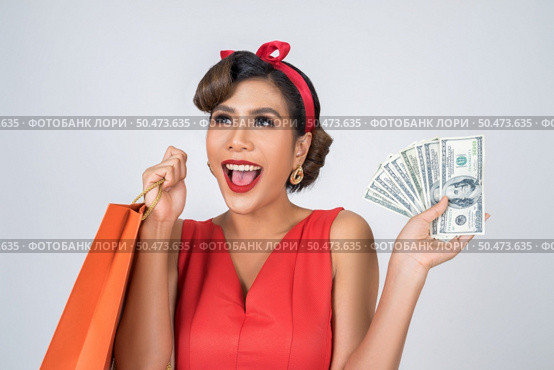 Beautiful asian woman holding colored shopping bags. Стоковое фото, агентство Ingram Publishing / Фотобанк Лори