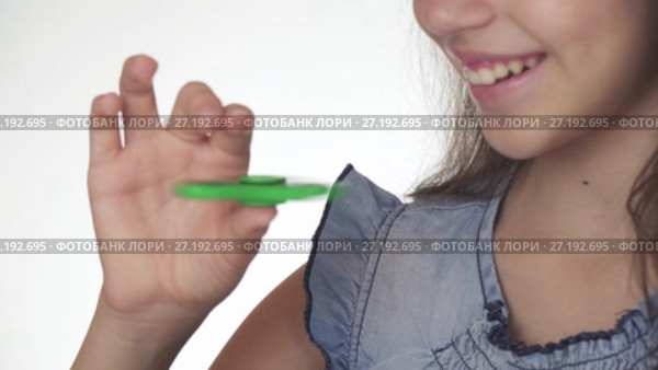 Beautiful cheerful teen girl playing with green fidget spinner on white background stock footage video. Стоковое видео, видеограф Юлия Машкова / Фотобанк Лори
