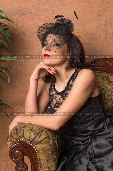 Beautiful dreamy girl in black dress sitting in antique chair retro three quarter. Стоковое фото, фотограф Андрей Пятницкий / Фотобанк Лори