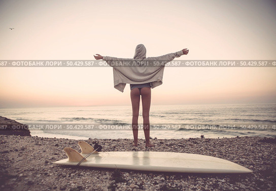 Beautiful female Surfer looking for the waves. Стоковое фото, агентство Ingram Publishing / Фотобанк Лори